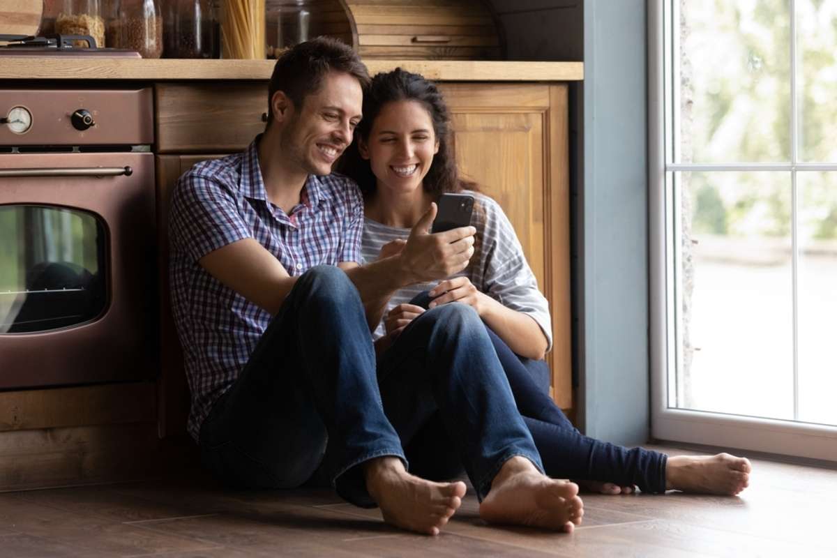 Smiling beautiful bonding family couple sitting on wooden floor