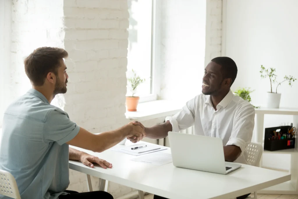 African american and caucasian businessmen shaking hands over