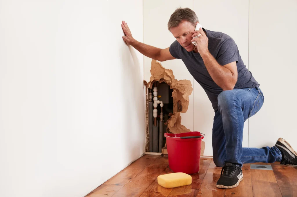 Middle aged man with a burst water pipe